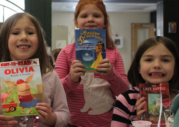 Happy classmates with books donated by Chris Hunt